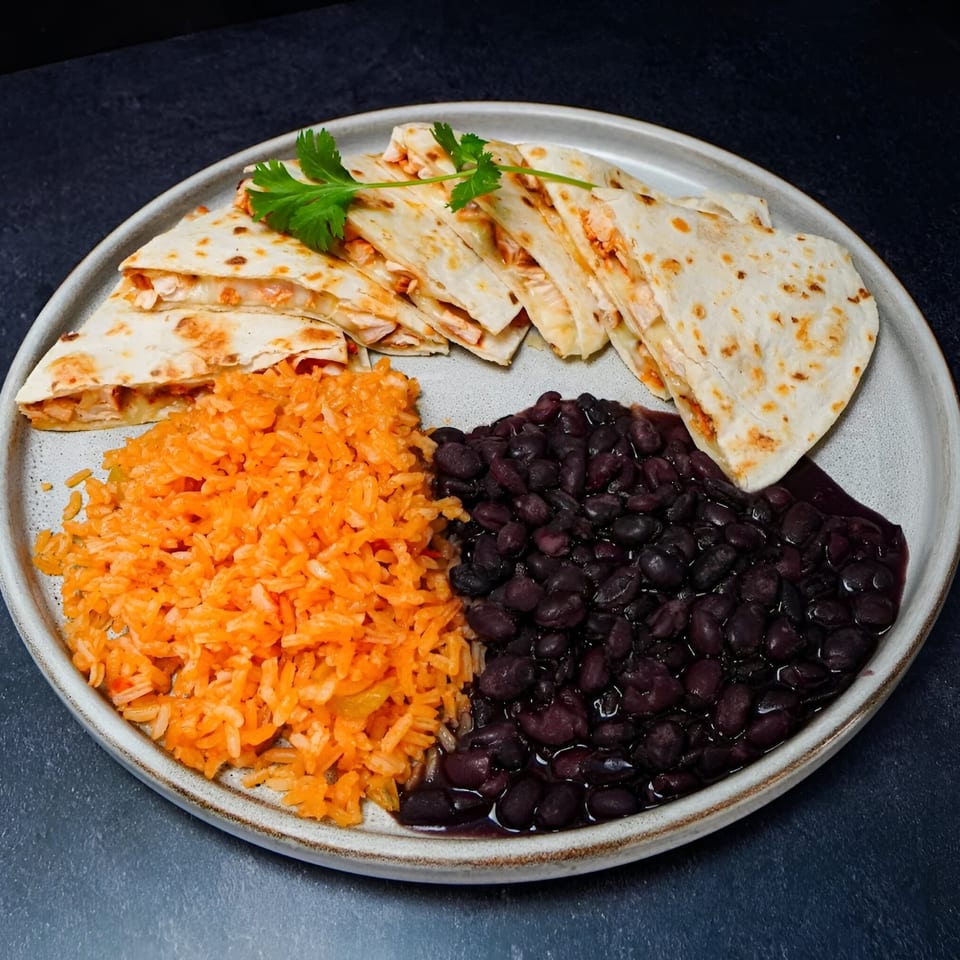 Cancun Express quesadillas with cilantro, orange rice, and black beans on a white plate.